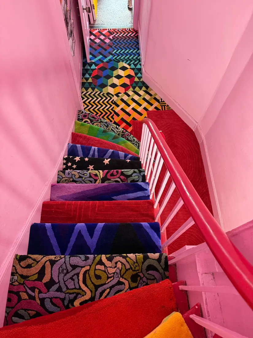 Colourful patterned carpet on a pink staircase